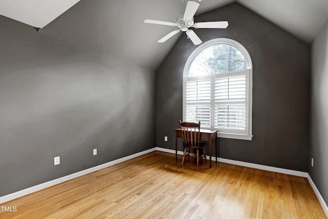 empty room featuring lofted ceiling, ceiling fan, baseboards, and wood finished floors