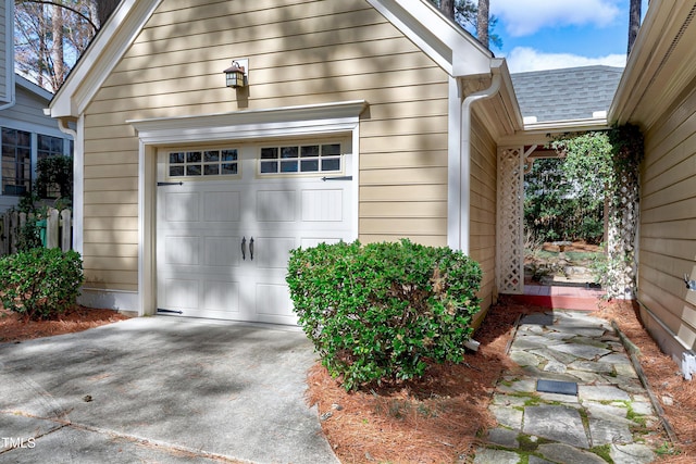 garage featuring concrete driveway