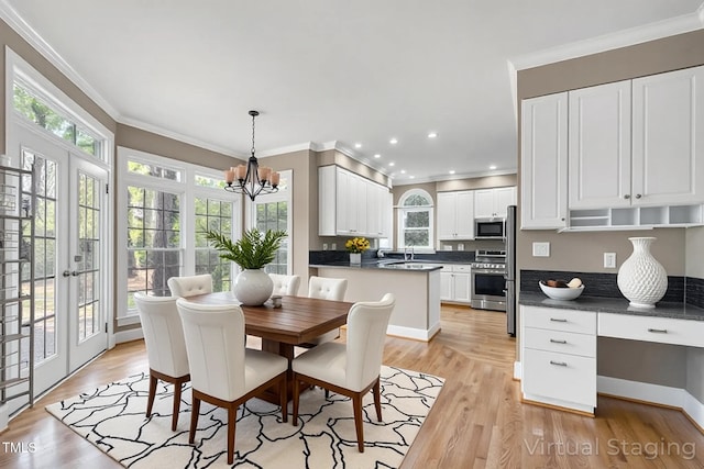 dining area with plenty of natural light, ornamental molding, and a notable chandelier