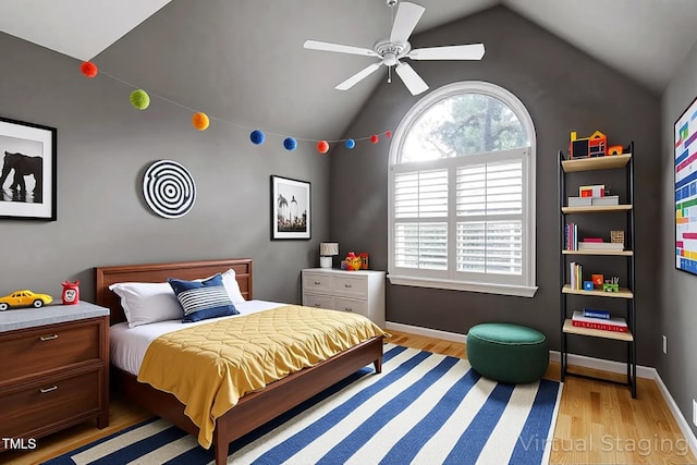 bedroom featuring baseboards, light wood-style flooring, and lofted ceiling