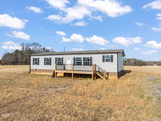 back of property with a lawn and a deck