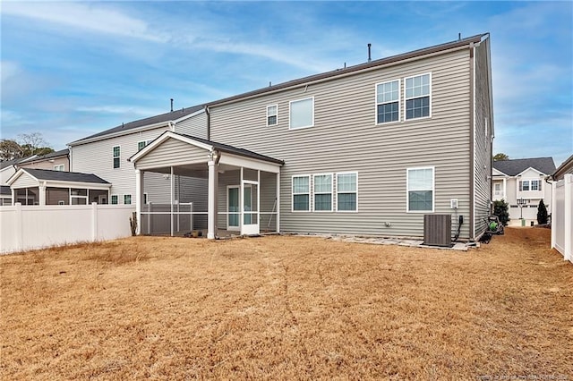 back of house featuring cooling unit, a yard, and a sunroom