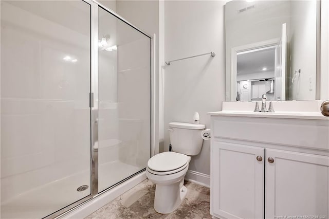 bathroom with vanity, a shower with door, and toilet