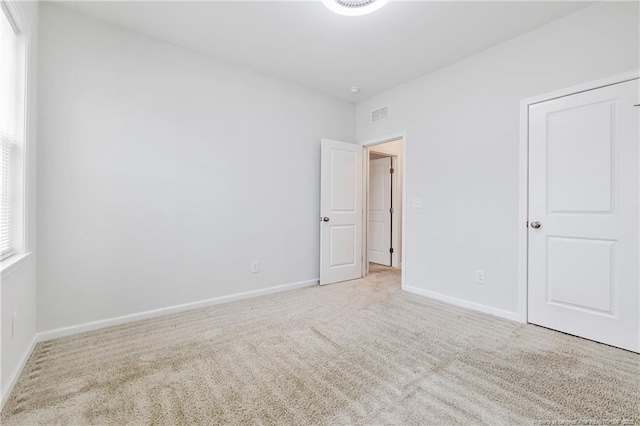 spare room featuring light colored carpet