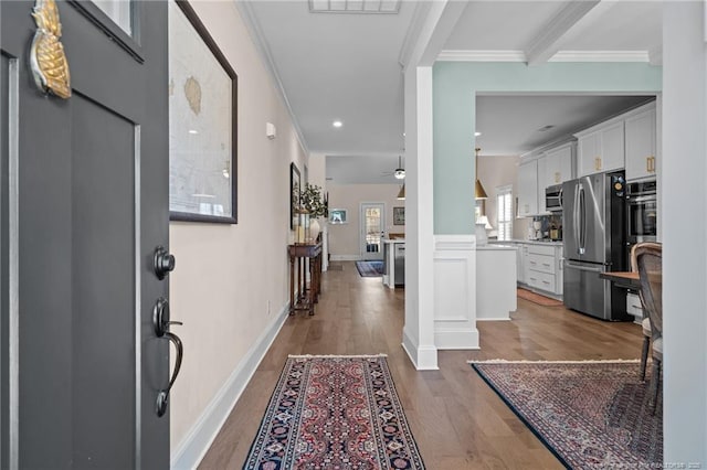 entryway featuring hardwood / wood-style floors, ceiling fan, ornamental molding, and beam ceiling