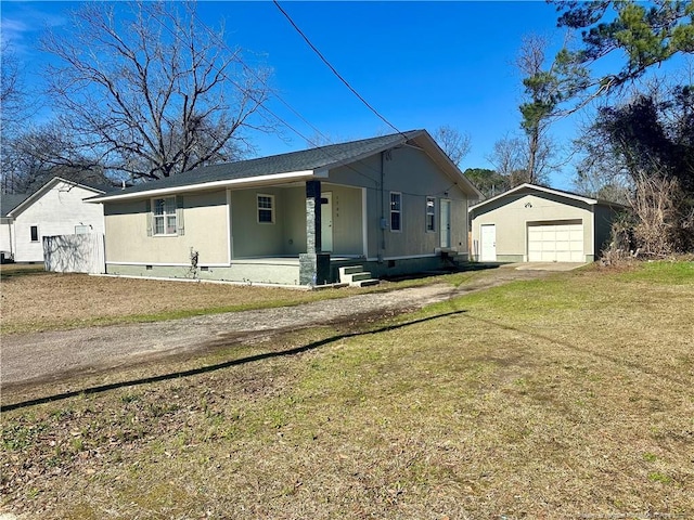 view of front of property featuring covered porch, a front lawn, an outdoor structure, and a garage