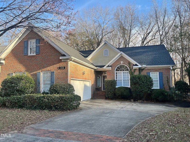 view of front facade featuring driveway, roof with shingles, a garage, and brick siding