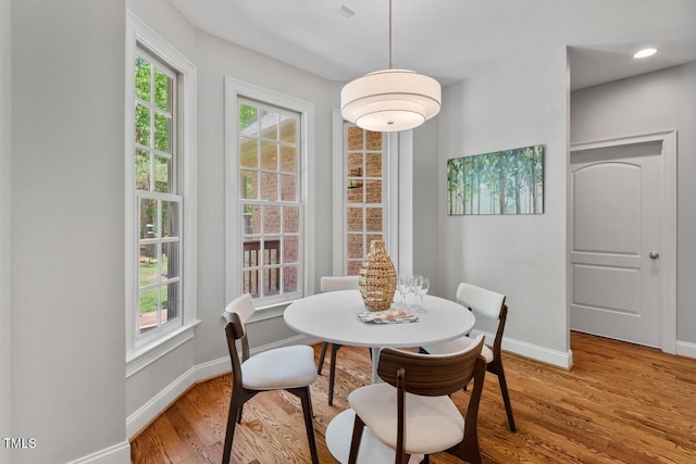 dining area with baseboards and light wood-type flooring