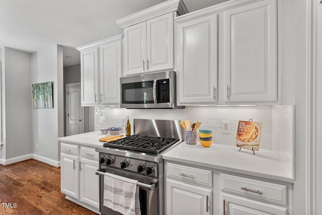 kitchen with baseboards, decorative backsplash, stainless steel appliances, and white cabinets