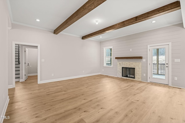 unfurnished living room featuring baseboards, light wood-style flooring, and a healthy amount of sunlight
