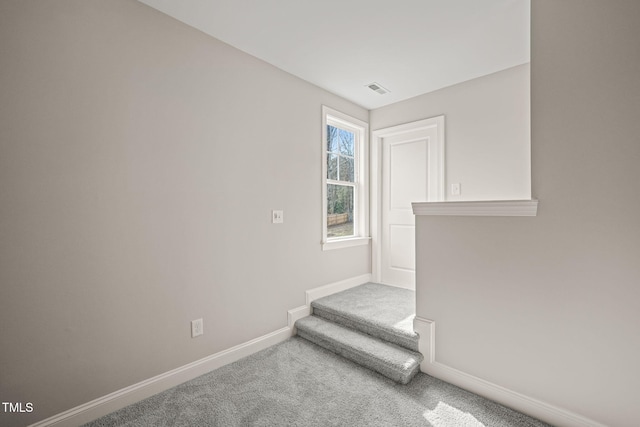 spare room featuring carpet floors, baseboards, and visible vents