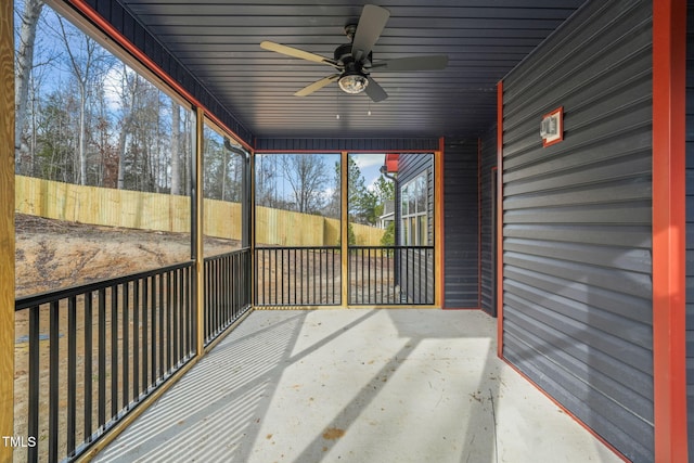 unfurnished sunroom featuring ceiling fan