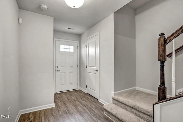 entryway featuring visible vents, stairs, baseboards, and wood finished floors