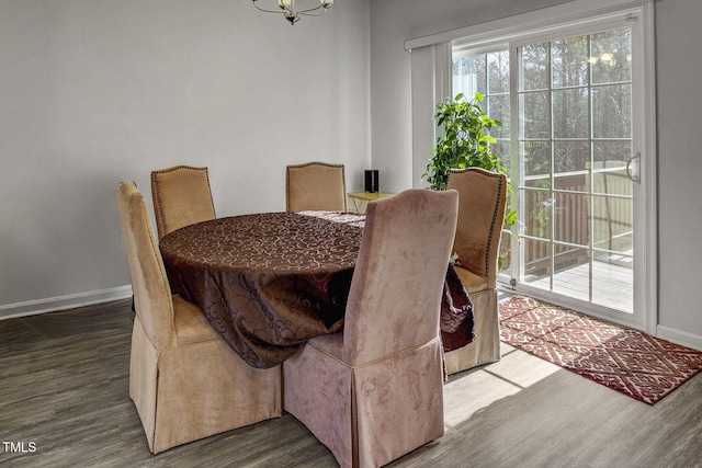 dining room with a notable chandelier, baseboards, and wood finished floors