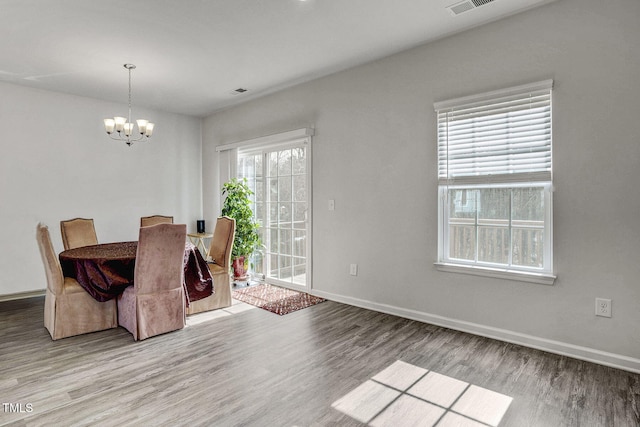 dining room featuring light wood finished floors, baseboards, and a chandelier