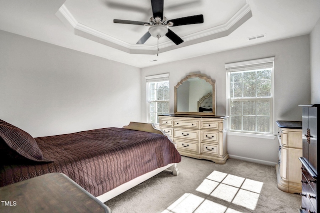 bedroom featuring ornamental molding, a raised ceiling, visible vents, and a ceiling fan