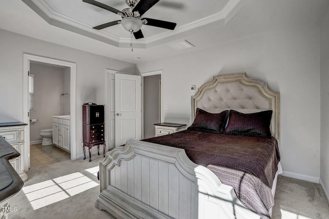 bedroom with a tray ceiling, light colored carpet, and crown molding