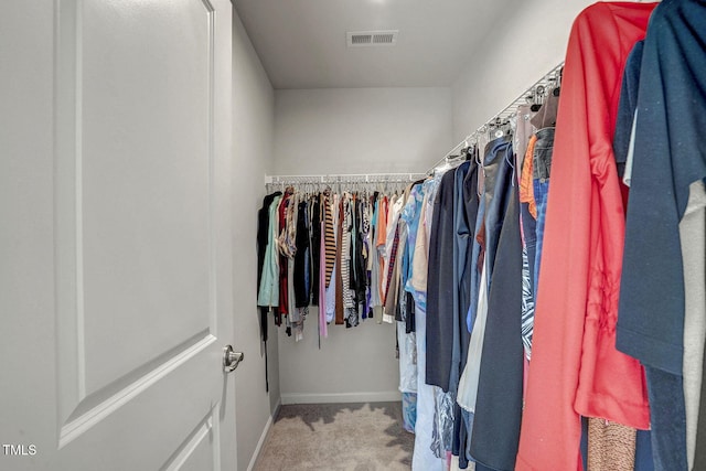 spacious closet featuring light colored carpet and visible vents