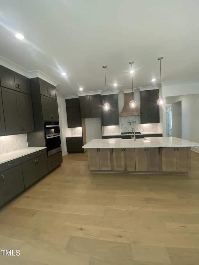kitchen featuring crown molding, light countertops, a spacious island, and tasteful backsplash