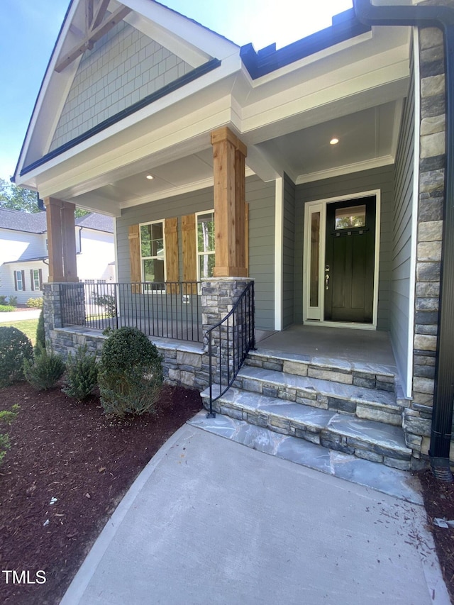 property entrance with covered porch and stone siding