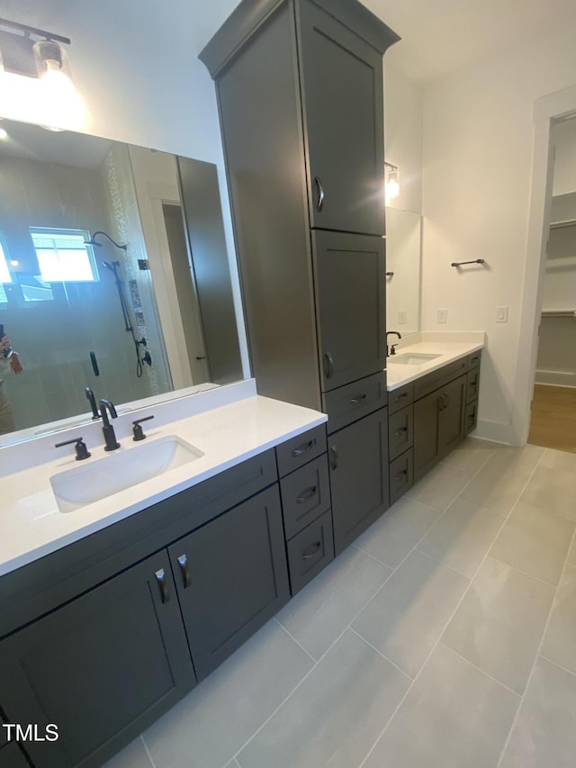 bathroom with a sink, two vanities, tile patterned floors, and a shower stall