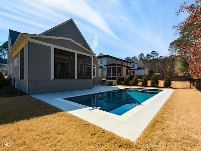 view of swimming pool with a lawn, a sunroom, and a patio area