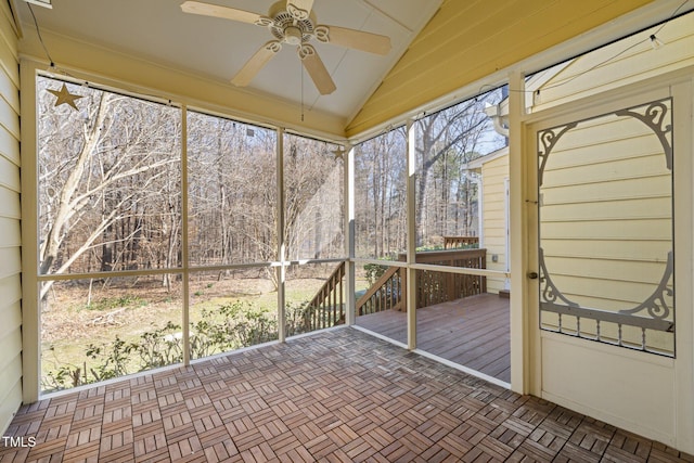 unfurnished sunroom featuring a ceiling fan and vaulted ceiling