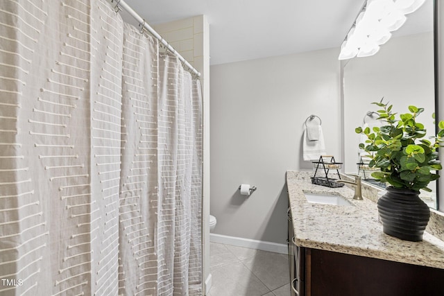 bathroom featuring toilet, tile patterned flooring, baseboards, and vanity