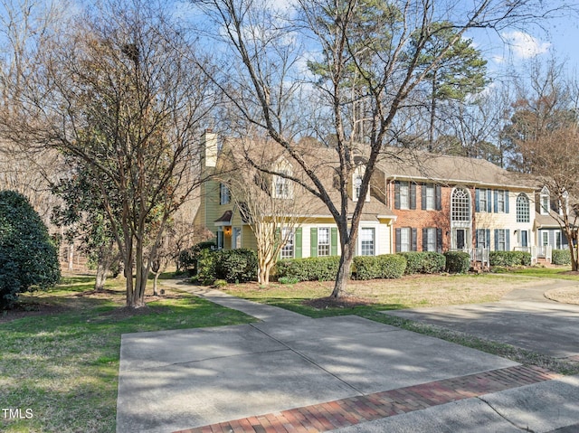 view of front of home featuring a front lawn and brick siding