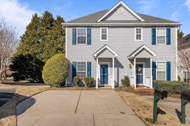 colonial house featuring a shingled roof