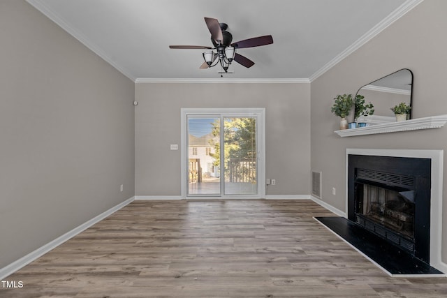 unfurnished living room with crown molding, light wood-type flooring, visible vents, and a fireplace with raised hearth