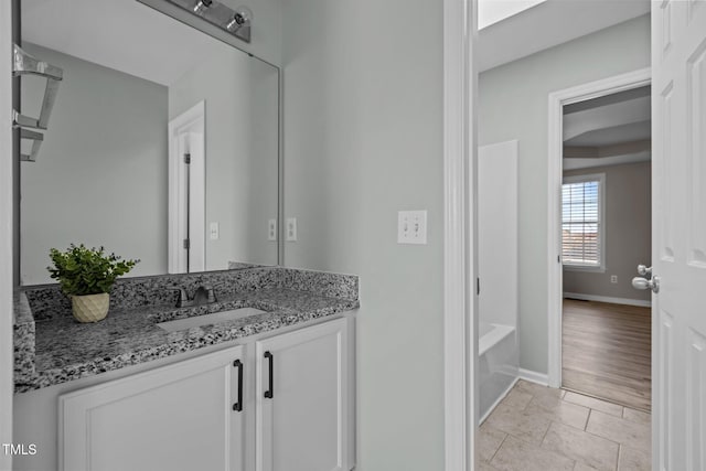 full bath with tile patterned floors, baseboards, and vanity