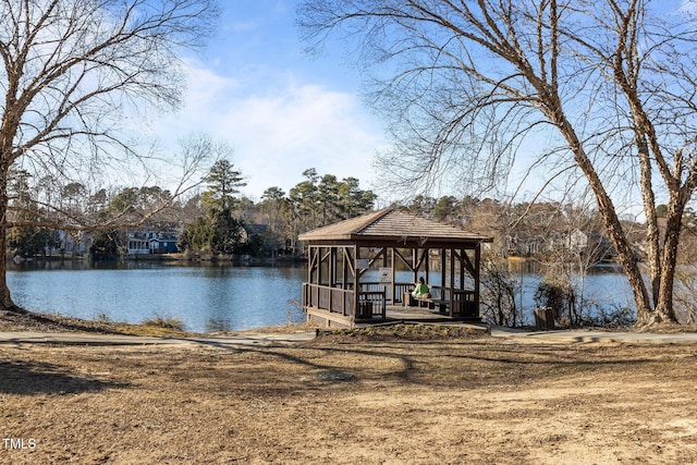 dock area with a gazebo, a lawn, and a water view