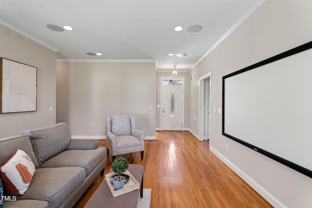 cinema room with light wood-type flooring and ornamental molding