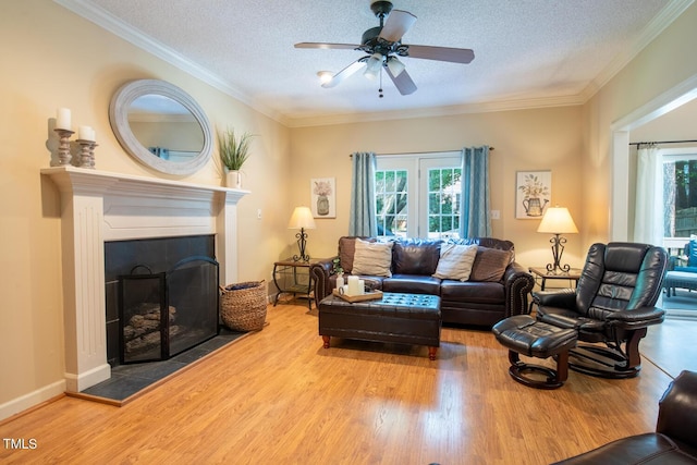 living area featuring a textured ceiling, a tile fireplace, wood finished floors, and crown molding