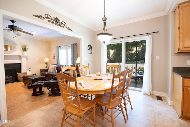 dining space featuring ornamental molding, visible vents, a fireplace, and baseboards