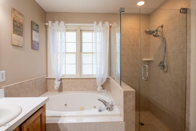 full bath with a whirlpool tub, a shower stall, and vanity