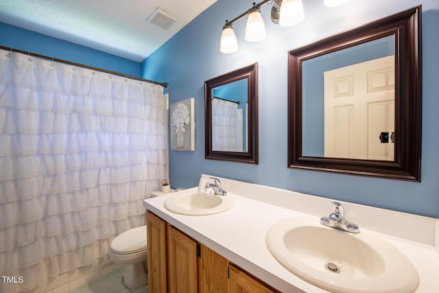 full bath featuring toilet, double vanity, visible vents, and a sink