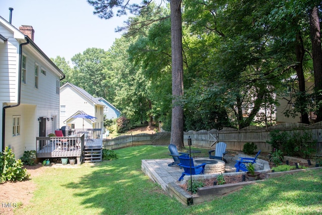 view of yard with an outdoor fire pit, a fenced backyard, and a wooden deck