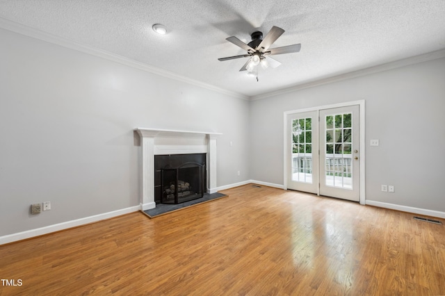 2006 Chedington Dr, Apex, NC 27502 - unfurnished living room featuring a ceiling fan, wood finished floors, a textured ceiling, crown molding, and a fireplace with raised hearth