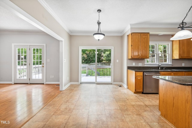 2006 Chedington Dr, Apex, NC 27502 - kitchen with stainless steel dishwasher, brown cabinets, crown molding, decorative light fixtures, and dark stone counters