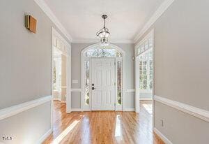 foyer featuring ornamental molding and wood finished floors