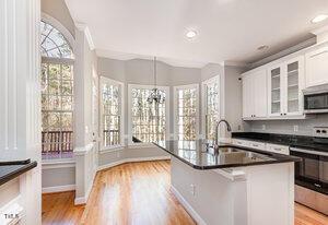 kitchen featuring stainless steel appliances, plenty of natural light, white cabinets, and a sink