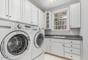 washroom with a sink, cabinet space, and washer and dryer