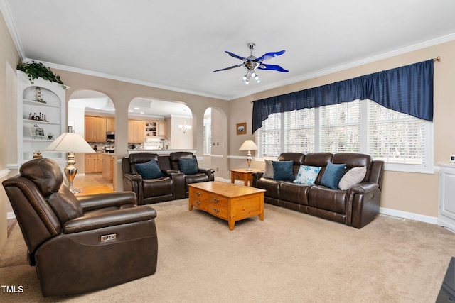 living area with a healthy amount of sunlight, arched walkways, ornamental molding, and light colored carpet