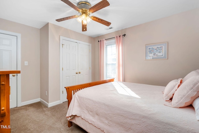 carpeted bedroom featuring a ceiling fan, a closet, visible vents, and baseboards