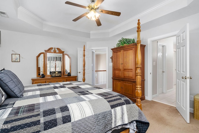 bedroom featuring a tray ceiling, light colored carpet, visible vents, ornamental molding, and ceiling fan