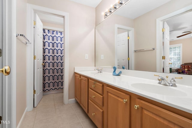 full bathroom featuring ceiling fan, double vanity, a sink, and tile patterned floors