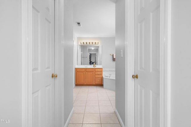 bathroom featuring tile patterned flooring, visible vents, baseboards, and vanity