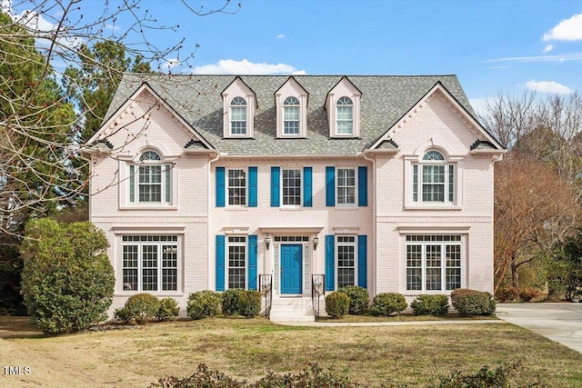 view of front of home with brick siding and a front yard